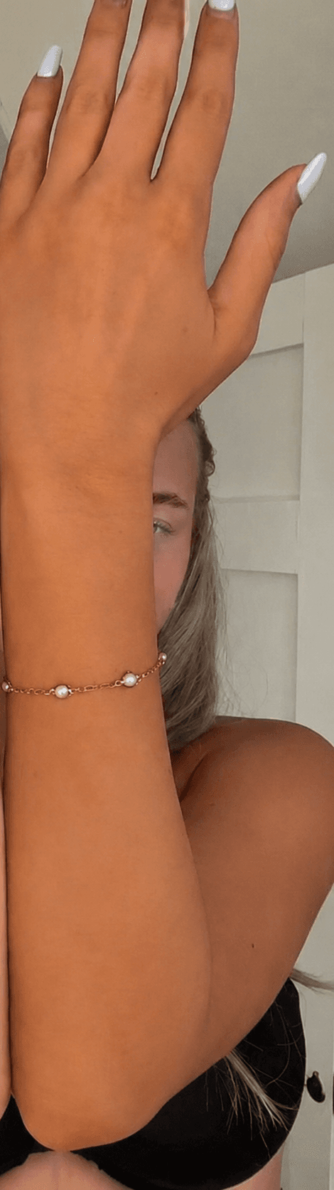 Self-tan after — arms-crossed mirror portrait — deeply tanned arm raised after the Dark mousse, eight-hour develop