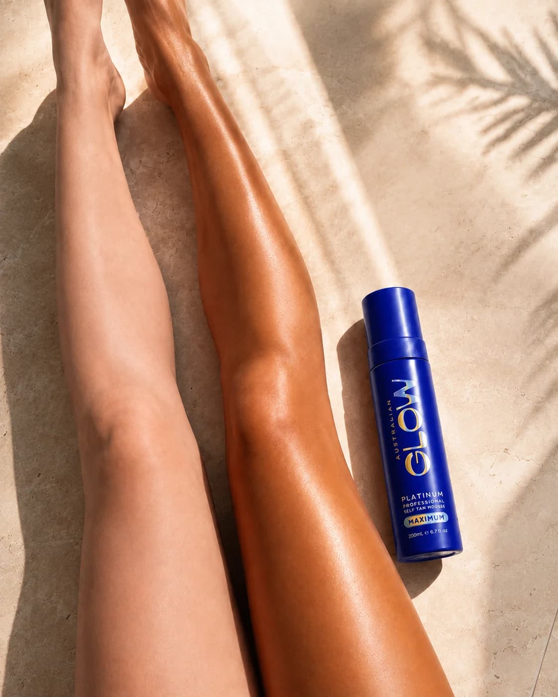 Freshly tanned legs on travertine in golden-hour sun