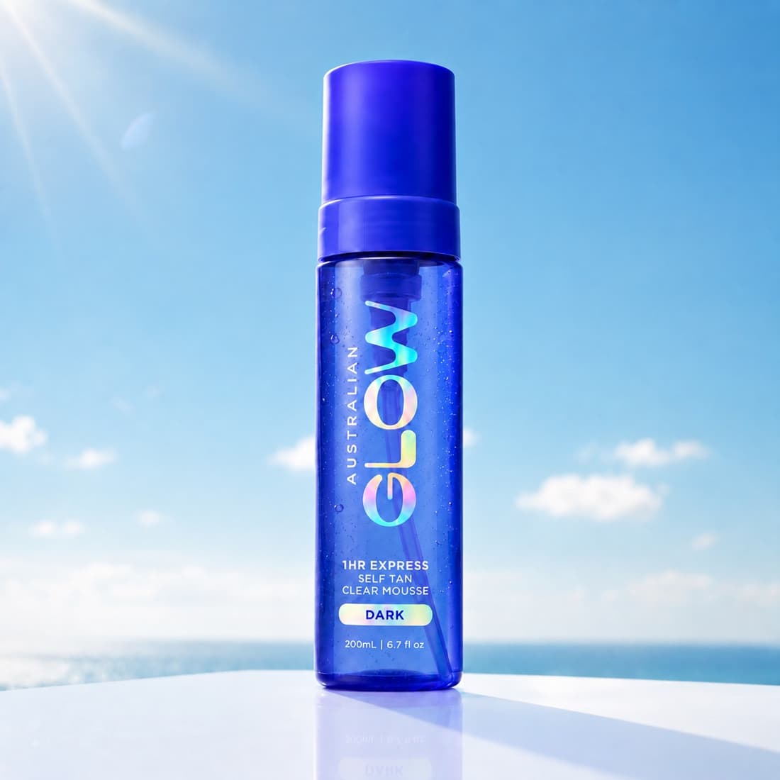 1HR Express Self Tan Clear Mousse in Dark on a plinth above the ocean
